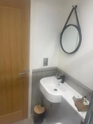 a bathroom with a white sink and a mirror at Millburn Mini Farm in Kilwinning