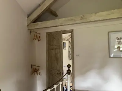 a hallway with a wooden door in a house at Annie's Cottage in Gosforth
