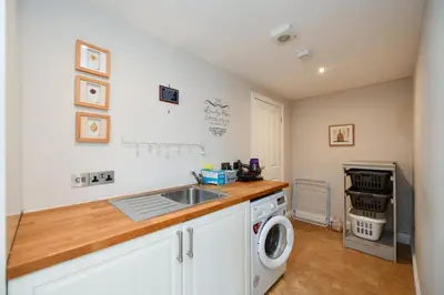 a kitchen with a sink and a washing machine at Arran View in Prestwick in Prestwick