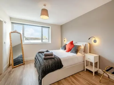 a bedroom with a bed and a mirror at Station Street Apartment in Cockermouth