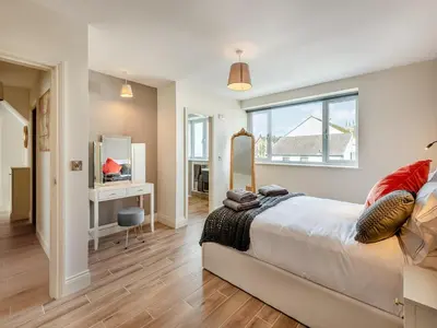 a bedroom with a large bed and a mirror at Station Street Apartment in Cockermouth