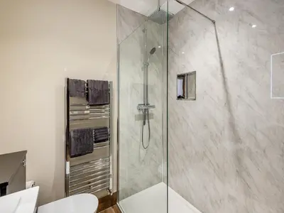 a shower with a glass door in a bathroom at Station Street Apartment in Cockermouth