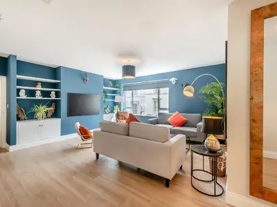 a living room with blue walls and a couch at Station Street Apartment in Cockermouth