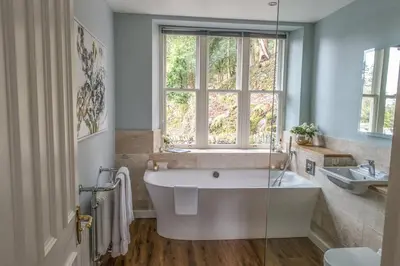 a bathroom with a large tub and a window at Forest Side Hotel in Grasmere