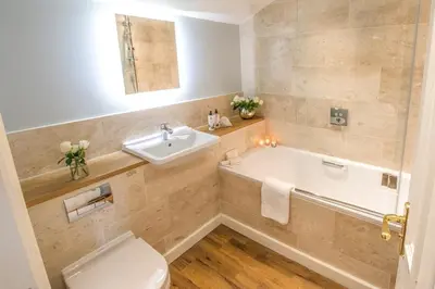 a bathroom with a tub and a sink and a toilet at Forest Side Hotel in Grasmere