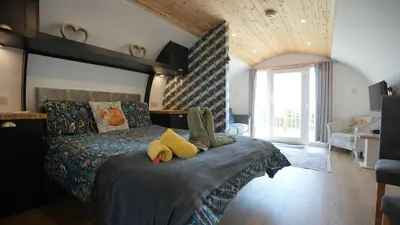 a bedroom with a bed with two stuffed animals on it at The Galloway Steading - The Fox's Den with Hot Tub and Fire Pit in Glenluce
