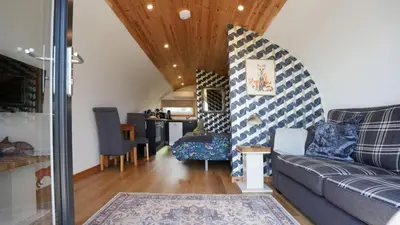 a living room with a couch and a table at The Galloway Steading - The Fox's Den with Hot Tub and Fire Pit in Glenluce