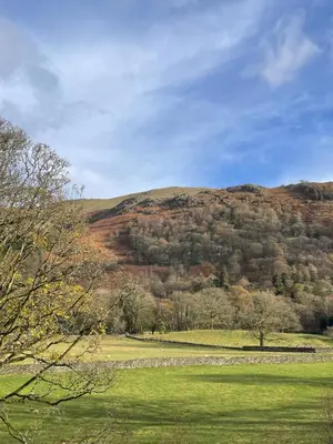 a grassy field with a hill in the background at Rothay Garden by Harbour Hotels in Grasmere