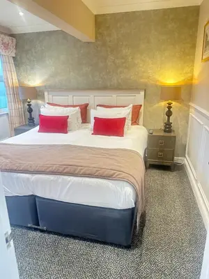 a bedroom with a large bed with two red pillows at The Inn At Grasmere in Grasmere