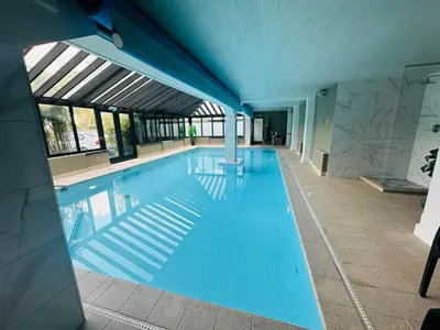 a large swimming pool with blue water in a building at The Inn At Grasmere in Grasmere