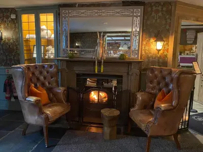 a living room with two chairs and a fireplace at The Inn At Grasmere in Grasmere
