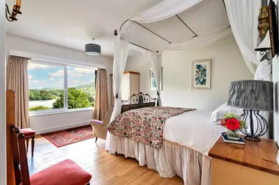 a bedroom with a bed and a large window at Finest Retreats - Unerigg in Grasmere