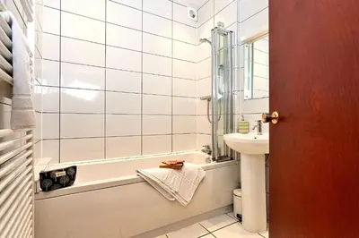 a white bathroom with a tub and a sink at Finest Retreats - Unerigg in Grasmere