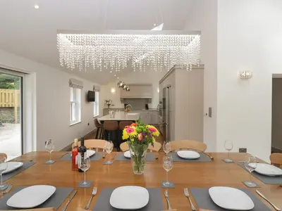 a dining room with a table and a chandelier at Heather's Cottage in Carlisle