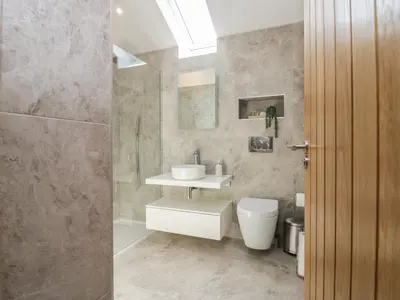 a bathroom with a toilet and a sink and a shower at Heather's Cottage in Carlisle
