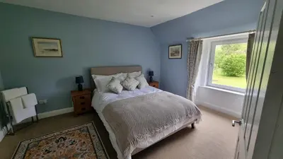 a blue bedroom with a bed and a window at Lady Farm - Bargany in Girvan
