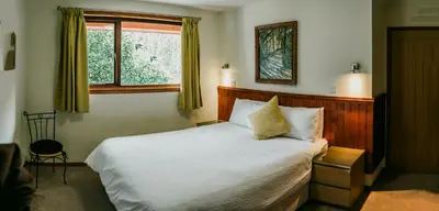a bedroom with a white bed and a window at Heatheryhaugh Lodges in Moffat