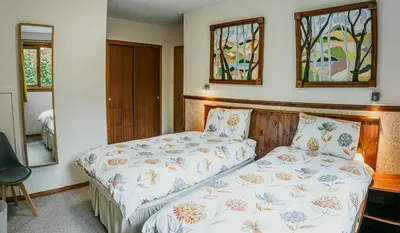 a bedroom with a bed and two windows at Heatheryhaugh Lodges in Moffat