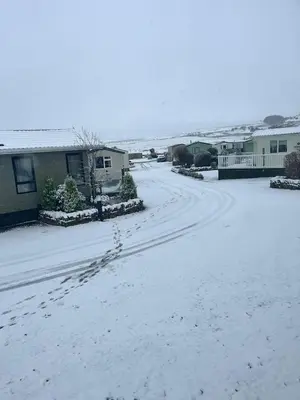a snow covered street with footprints in the snow at 19 Forest Views in Plumbland
