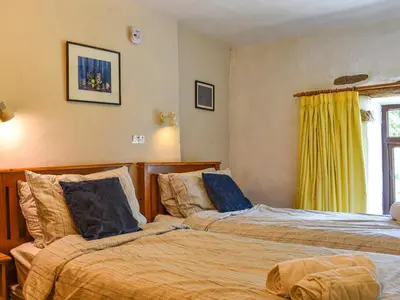 two beds sitting next to each other in a bedroom at Church House in Ulpha