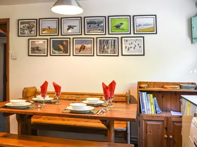 a dining room table with red napkins on it at Church House in Ulpha