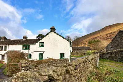 a white house with green doors and a stone wall at Finest Retreats - Town Head Cottage in Grasmere in Grasmere