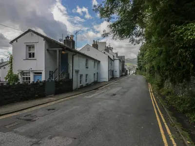 an empty street with white houses on the side at Style Cottage in Keswick