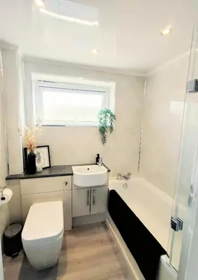 a bathroom with a toilet and a sink and a tub at Troon Golf and Beach House in Troon