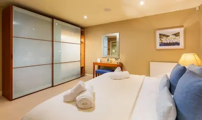 a bedroom with a large white bed with towels on it at Underscar - Latrigg in Keswick