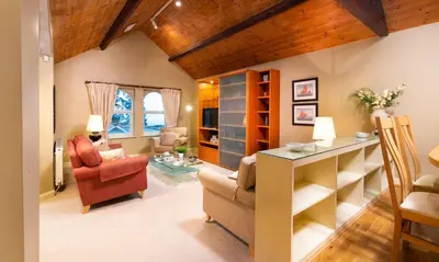 a living room with a red chair and a table at Underscar - Latrigg in Keswick