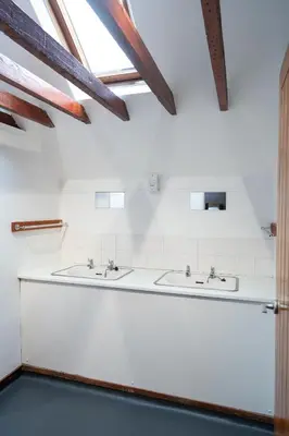 two sinks in a white bathroom with exposed beams at Weirside, Chapel Stile in Ambleside
