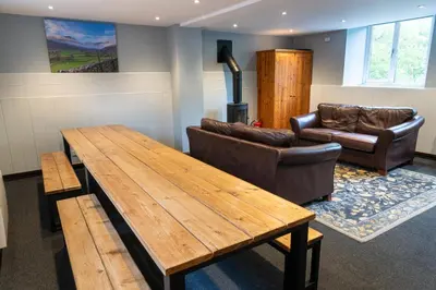 a living room with a wooden table and a couch at Weirside, Chapel Stile in Ambleside