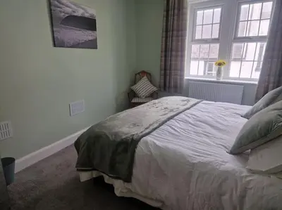 a bedroom with a large bed and a window at The Old Bank at St Bees, Western Lakes in St Bees