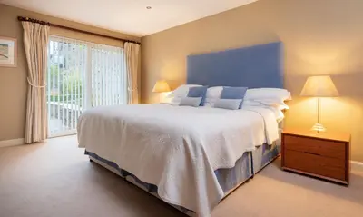 a bedroom with a large bed and a large window at Underscar - Beckstones in Keswick