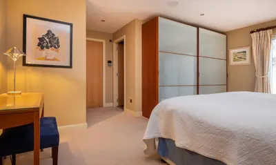 a bedroom with a bed and a table and a desk at Underscar - Beckstones in Keswick