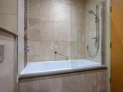 a bathroom with a bath tub and a shower at Underscar - Grange in Keswick