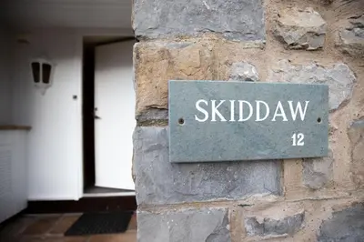 a sign on the side of a stone wall with the word skid dawn at Underscar - Skiddaw in Keswick
