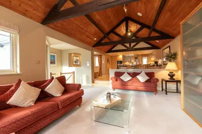 a living room with red couches and a wooden ceiling at Underscar - Skiddaw in Keswick
