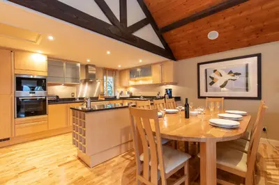 a kitchen with a wooden table and a wooden ceiling at Underscar - Skiddaw in Keswick