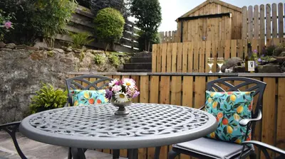 a table and two chairs with a vase of flowers on it at Little Egret in Carsethorn