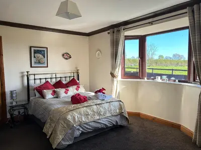 a bedroom with a bed with red pillows and a window at wonderful 4 bedroom cottage sleeps 8 in Carlisle
