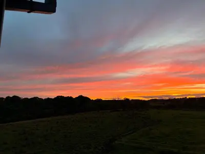 a sunset over a field with trees in the background at wonderful 4 bedroom cottage sleeps 8 in Carlisle