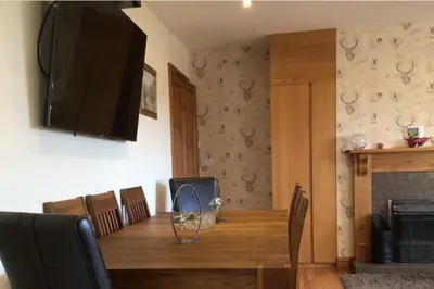 a dining room with a table and a television on the wall at wonderful 4 bedroom cottage sleeps 8 in Carlisle