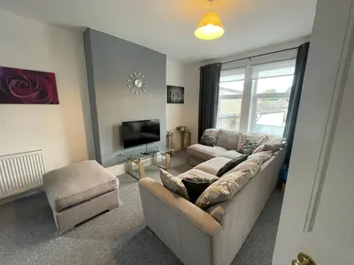a living room with a couch and a tv at DG1 1ST Floor Flat in Dumfries