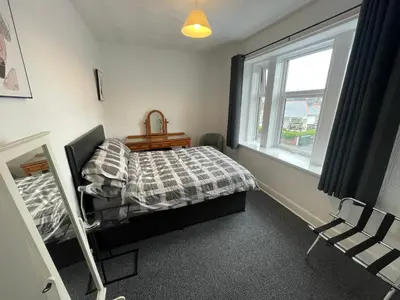 a bedroom with a bed and a window at DG1 1ST Floor Flat in Dumfries