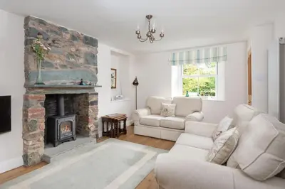 a living room with a couch and a fireplace at Lydia's River Cottage in Keswick