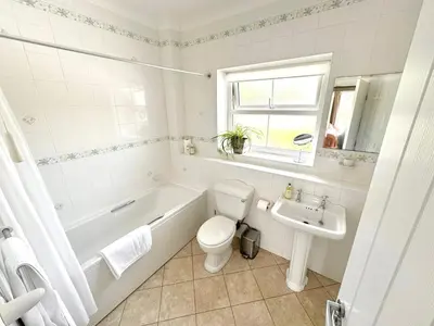 a bathroom with a tub and a toilet and a sink at Kionslieu Farm Cottages in Foxdale