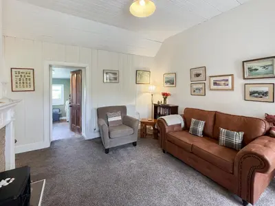 a living room with a couch and a chair at Rose Cottage in Port Logan