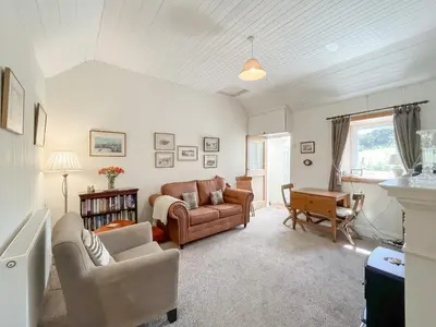 a living room with a couch and a table at Rose Cottage in Port Logan