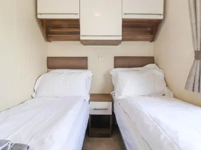 two beds in a small room with white sheets at 31 Forest Views in Cockermouth